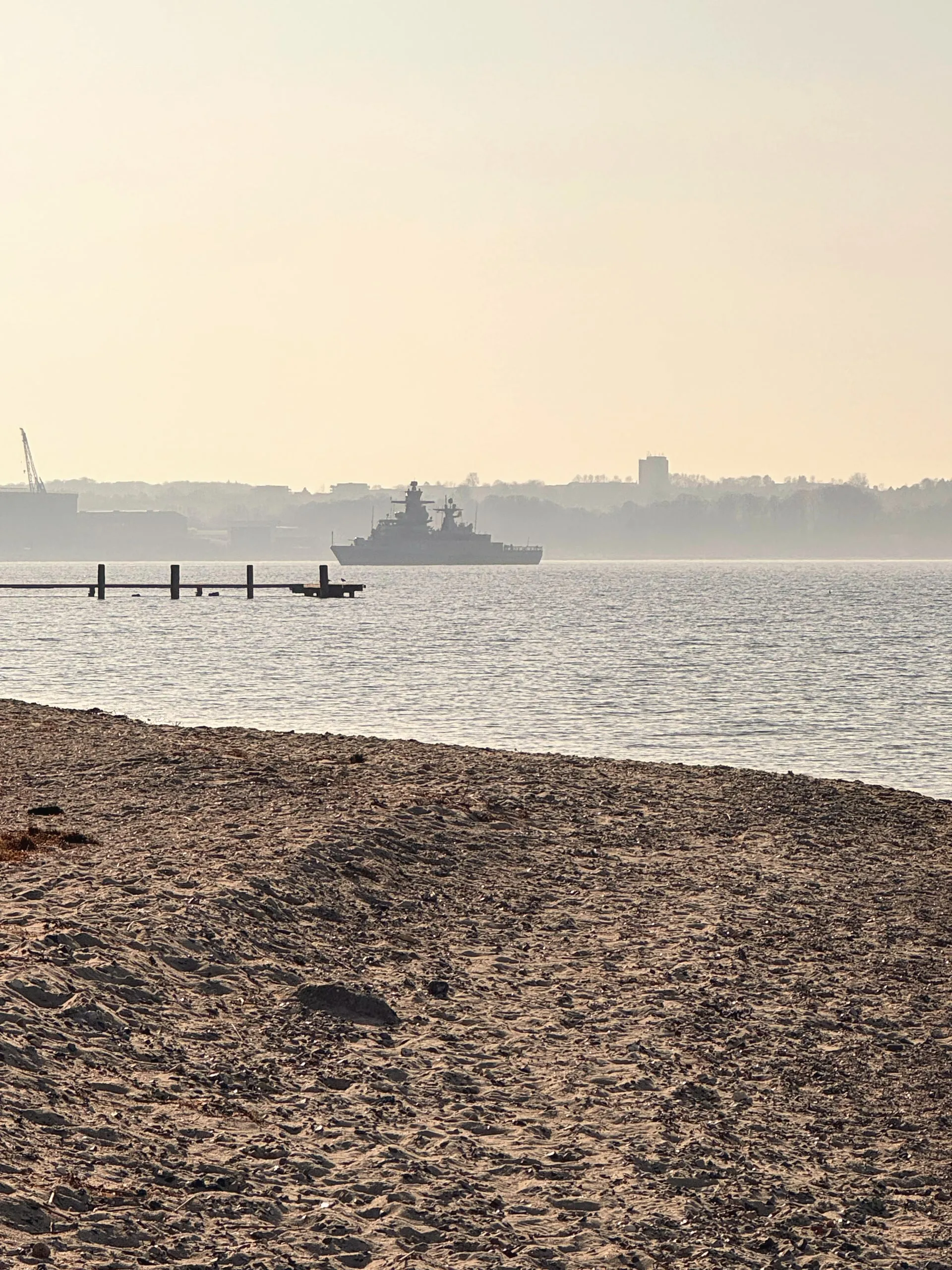 Marineschiff im Dunst vor Fahrensodde, vorn der Strand